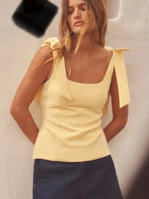 Gul linnetopp med rosetter - Söt ljusgul linnetopp med breda axelband som knyts i stora rosetter på axlarna. Perfekt för varma dagar. Från Zara använd 2 gånger 