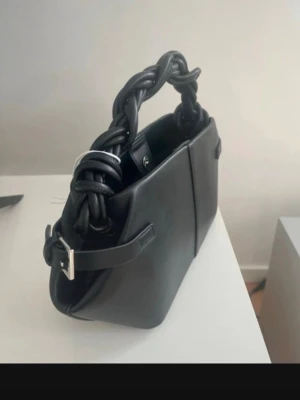 Slutsåld väska från Gina Tricot - Stilren svart handväska från Gina Tricot i slätt konstläder. Helt ny och oanvänd 