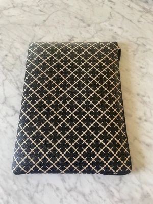 Svart mönstrad datorväska från By Malene Birger - Snygg datorväska från By Malene Birger i svart med vitt grafiskt mönster. Väskan har dragkedja, innerfack och beige insida. Perfekt för laptop eller surfplatta och ger en stilren look till plugget eller jobbet.