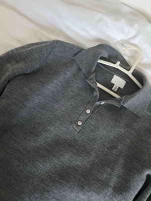 Grå långärmad tröja med krage H&M - Snygg grå långärmad tröja från H&M med klassisk krage och tre knappar framtill. 