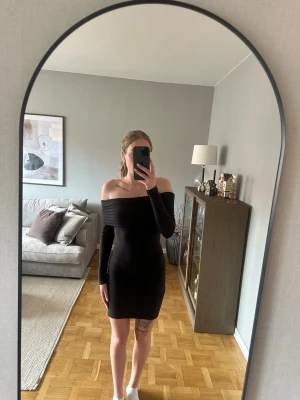 Svart off shoulder klänning - Snygg svart  off shoulder klänning och långa ärmar. Aldrig andvänd. 