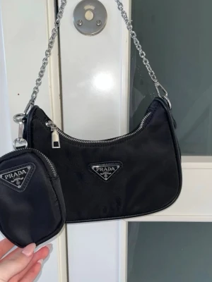 Svart axelremsväska från Spanien - Snygg svart axelremsväska från Spanien och kommer med en matchande liten avtagbar miniväska, Vet tyvärr inte vart den är ifrån, men den är köpt i Spanien💞