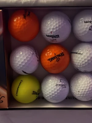 Flerfärgade golfbollar från olika märken - Säljer ett mixat set golfbollar i vitt, orange och gult från märken som Wilson, Spalding, Titleist och Callaway. Klassisk dimple-design för bra bollflykt. Perfekt för dig som vill ha variation på golfbanan.