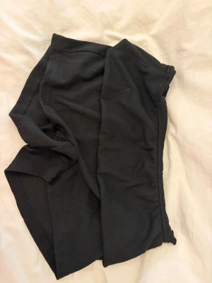 Svarta ribbade shorts - Säljer ett par svarta ribbade shorts med low waist passform. Perfekta för varma dagar och enkla att matcha med olika toppar. Mjukt och stretchigt material för extra komfort.