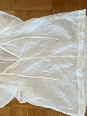 Vit blus med knytband - Säljer en fin vit blus med knytband . Blusen har en avslappnad passform och är tillverkade i tunt tyg.