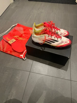 Adidas F50 Elite fotbollsskor - Adidas F50 Elite fotbollsskor. Vita med detaljer av röd. Allt på bilden ingår. Pris kan diskuteras! 