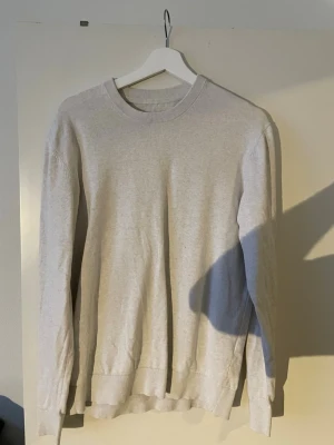 Ljusgrå basic sweatshirt These Glory Days - En enkel ljusgrå sweatshirt med rund hals och långa ärmar. Tröjan har ribbade muddar vid ärmslut och nederkant, och är tillverkad i mjukt material som passar perfekt till en avslappnad stil.