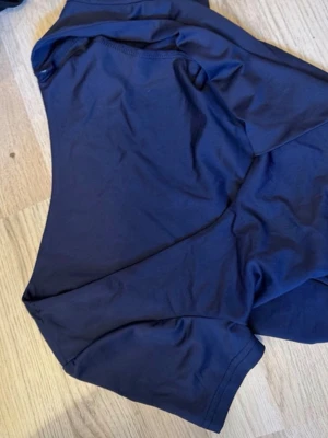 Mörkblå basic t-shirt - En enkel och stilren mörkblå t-shirt i mjukt bomullsmaterial. T-shirten har klassisk passform med rund halsringning och korta ärmar. Perfekt att matcha med jeans eller shorts för en clean look.