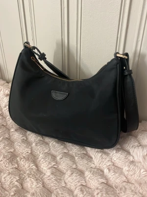 Svart liten handväska - Svart mindre handväska med gulddetaljer, lite sliten. Skriv för mer frågor☺️
