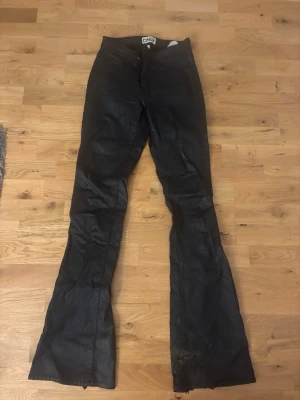 Svarta bootcut skinnbyxor från ONLY - Snygga svarta bootcut skinnbyxor från Only i storlek M, byxorna är lite slitna nertill men annars är de i bra skick🥰