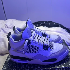 Air Jordan 4 Retro Military Black - Säljer ett par Air Jordan 4 Retro Military Black. Skorna har klassisk meshpanel, snörning och den ikoniska Jumpman-loggan på hälen. Snygg och tidlös modell med platt sula och rund tå. Perfekta för dig som gillar streetwear. Priset är inget hugg i sten men skorna är i bra skick!