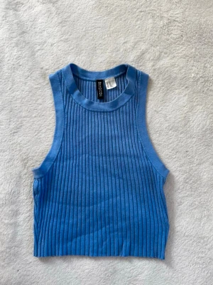 Stickad stretchig topp - Blå stickad topp från H&M i storlek XS med kort passform. Väldigt stretchigt material, passar mig som använder storlek M. 