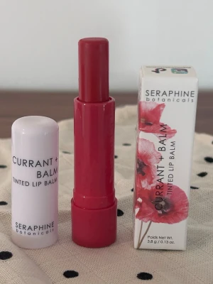 Seraphine botanicals Lip Balm läppbalsam - Tinted lip balm från Seraphine Botanicals i färgen Cranberry. Återfuktar samtidigt som det ger en snygg hint av röd färg. Nytt och oanvänt.