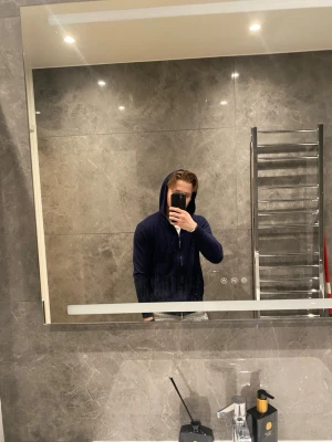 Mörkblå hoodie med dragsko - Snygg mörkblå hoodie med huva och dragsko. Klassisk modell med lång ärm och avslappnad passform. Perfekt för dig som gillar en enkel och stilren look. Passar till det mesta och är superbekväm.