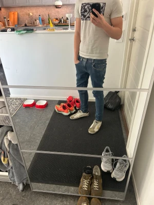 Blå slim fit jeans herr - Säljer ett par blå slim fit jeans med klassisk femficksdesign och normalhög midja. Passar mindre än vad storleken är. Jeansen har smal passform hela vägen ner och är tillverkade i ett stretchigt denimtyg för extra komfort. Perfekta till sneakers och t-shirt för en avslappnad look.