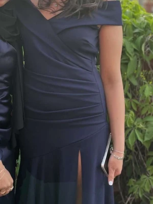 Marinblå balklänning  - Säljer denna fina balklänning som jag hade när jag gick ut 9an 2023❤️den är lite off shoulder nästan med slits nedtill!! Super fin och välgjort material. Passar perfekt till bal eller bröllop😊 Jag har bara använt klänningen 1 gång!! Skriv om ni har någon fundering