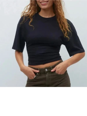 Svart tröja som går in i midjan  -  Toppen har en tight passform över midjan från Gina tricot 