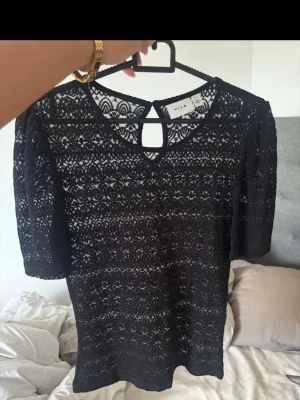 Svart spetsblus från Vila - Säljer en svart blus från Vila med vackert spetsmönster och rund halsringning. 