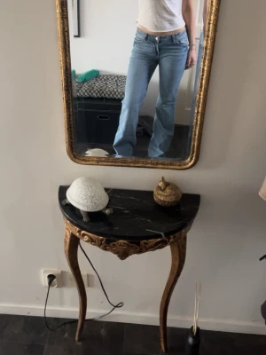 Ljusblå bootcut jeans - Säljer ett par ljusblå bootcut jeans med klassisk femficksdesign och normal midja. Jeansen har en avslappnad passform över låren och utsvängda ben. Perfekta för en trendig och avslappnad stil.