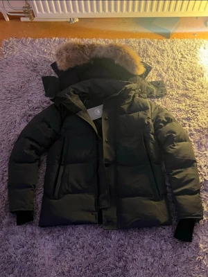 Canada goose wyndham vinterjacka black label - Jackan är helt oanvänd i nyskick som på bild, tagsen ligger kvar.   Ingen problem alls helt felfritt jacka.  Rökfritt och djurfritt hus  Fraktas samma dag vid köp  (står även för frakt.)  Behöver rensa ut garderoben och hoppas att någon annan kan få lika mycket glädje av denna fantastiska jackan.