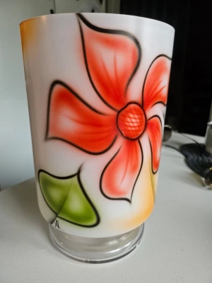 Vas/Lykta Nybro glasbruk - Lyktan/vasens design är inspirerad av tatueringskonst och skapad med en airbrushteknik.Den är handmålad och tillverkad i satinerat glas. Formgiven av Anders Lindblom. Ca 24 cm hög och 15 cm i diameter.