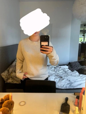 Beige stickad tröja - Mysig beige stickad tröja med rund halsringning och långa ärmar. Tröjan har ribbstickade muddar vid ärmslut och nederkant, vilket ger en klassisk och enkel look. Perfekt att matcha med jeans eller kjol för en avslappnad stil. 🩷 kanske lite nopprig men annars jättefint skick