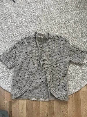 Beige stickad kortärmad kofta - Jätte gullig tröja💛 Passar S/M/L då man kan välja hur man vill att den ska sitta genom knyt banden