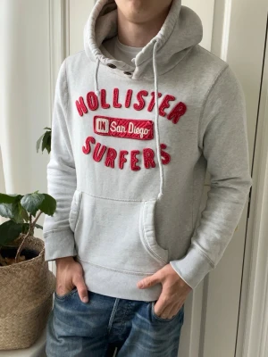 Hollister hoodie surf - Hollister hoodie, sjukt schysst. Inga defekter! Modellen i bilderna är 180 cm 75 kg och bär Storlek M , Kom med frågor! 🌟 (Kan gå ned i pris vid köp av paket 😉) 