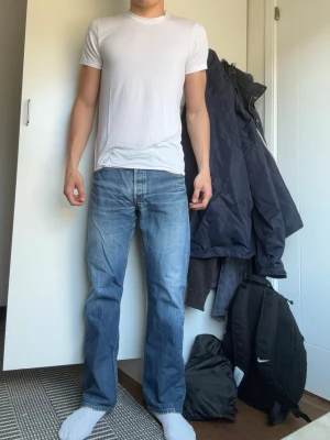 Levi's 501 jeans - Riktigt snygga jeans från Levis i mörkblå denim (W32, L32) med cool tvätt och worn känsla. Ger riktiga archive/vintage vibbar. Skön passform och sitter riktigt bra på (straight fit). Modellen är 180 och väger 76 kg. Säljer för endast 399kr.