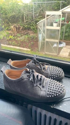 Gråa sneakers med nitar - Unika grå sneakers i mocka-look med coola grå nitar över tån. Skorna har rundad tå, matchande grå skosnören och svart sula. Perfekta för dig som vill sticka ut med en edgy stil. Pris kan diskuteras!