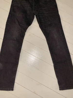 Mörkgrå slim/glenn jeans från Jack&Jones - Säljer ett par mörkgrå slim/glenn jeans i storlek 28/30 från Jack&Jones. Jeansen är tillverkade i denim och är perfekta för dig som gillar en enkel och stilren look. Hör av dig vid minsta fundering!💯💯