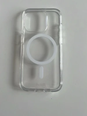 skal från Holdit för iPhone 15 pro - Snyggt genomskinligt mobilskal från Holdit med vit MagSafe-ring. Skalets material är tålig plast och det har en stilren design.