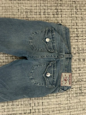Blå jeans från True Religion - Så snygga blåa jeans från True religion i storlek 23 vilket motsvarar typ XXS och Xs❤️nypris 1300 kr! Den enda defekten är nere vid foten vilket man kan tvätta bort!