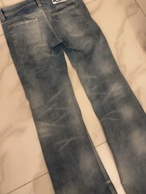 Ljusblå utsvängda jeans från creap monday  - Säljer ett par ljusblå jeans från creap monday med utsvängda ben och klassisk femficksdesign. Jeansen har en snygg tvättad look och är tillverkade i denim. Perfekta för dig som gillar retrostil och vill ha ett par trendiga jeans.