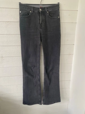 Svarta bootcut jeans med hög midja - Snygga svarta jeans ifrån hm med bootcut passform och hög midja. Klassisk femficksmodell med knappgylf och raka bakfickor