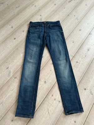 Mörkblå jeans från Jack & Jones - Snygga mörkblå jeans från Jack & Jones, modell slim fit Glenn, klassisk femficksdesign. Storlek 28x32. Mycket fint skick, aldrig använda, köpta nya. Perfekta för en avslappnad och stilren look.