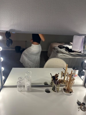 Vit långkjol i bomull - Säljer en snygg vit långkjol i bomull med lätt volang och flowig passform. Kjolen har en enkel och stilren design som passar perfekt till sommaren. Midjan är elastisk för extra komfort och kjolen är helfärgad utan mönster.
