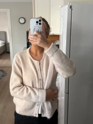 Beige kofta med knappar - Säljer en mysig beige kofta med rund halsringning och knäppning framtill. Koftan är stickad i ett mjukt material och har långa ärmar💞