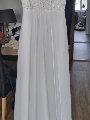 Vit bröllopsklänning - Vit bröllopsklänning i nyskick! Använd 1 dag. Passar mig perfekt som är 174cm lång ,bh storlek 75B. Storlek S/M skulle jag gissa på. Köpt i butik i Göteborg, minns inte vad den hette.. 