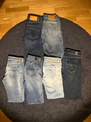 6 par jeans i olika blå nyanser - Säljer ett paket med sex par jeans i olika blå tvättar, från ljusblått till mörkblått. Klassisk femficksmodell med raka och smala ben. Några har läderpatch på linningen och synliga sömmar. Perfekta för dig som gillar varierad denimstil.