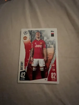 Match Attax fotbollskort Manchester United - Säljer ett Match Attax samlarkort från Topps med Manchester United-tema. Kortet visar en spelare i röd matchtröja och vita shorts, med klubbens logga och statistik på framsidan. Perfekt för dig som samlar på fotbollskort eller gillar Premier League.