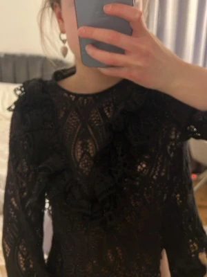 Svart spetsblus med volangdetaljer❤️ - Säljer en svart blus i spets med långa ärmar och volangdetaljer framtill. Säljs inte längre och är super unik! Pris kan sänkas vid snabb affär!.❤️❤️