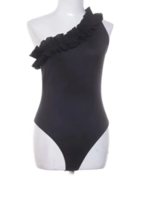 Svart body med volang och en axel - Säljer denna superfina bodyn ifrån hm i st M och den är helt slutsåld och verkligen populär. De finns också kvar prislapp på den. Prislapp är ifrån Sellpy 