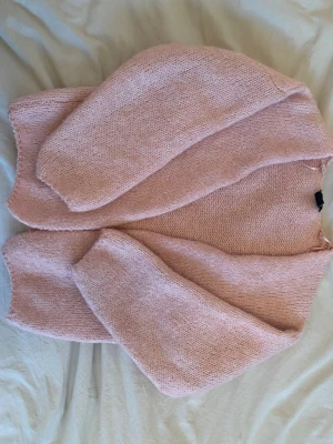 Ljusrosa stickad tröja - Mysig ljusrosa stickad tröja med avslappnad passform och långa ärmar. Tröjan har en enkel design utan synliga detaljer eller mönster. Tröjan är köpt ifrån Lindex