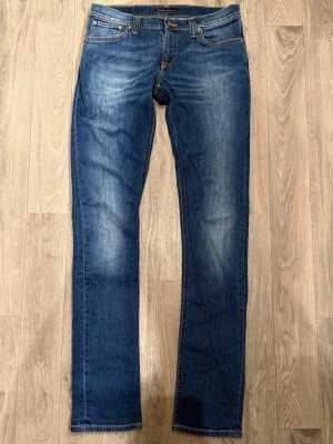Nudie Jeans Tight Long John Blå W30 L34 - Mycket fint skick. Storlek W30/L34. Mått - Midja: 39,5cm, Ytterbenslängd: 106,5cm, Benöppning: 16cm. Modellen är 185cm & 63kg. Hör av dig vid funderingar!🤝