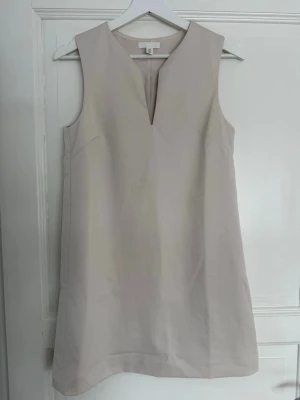 Beige cocktail klänning - Säljer en beige kortklänning med v-ringad hals💕