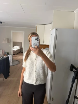 Vit kortärmad kofta med pärlknappar - Säljer en mysig vit kofta med korta ärmar och rund hals. Knäpps framtill med dekorativa pärlknappar💞