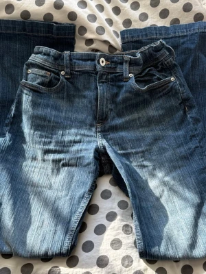 Utsvängda jeans - Säljer ett par blåa jeans med utsvängda ben. Jeansen är från H&M i storlek 158 och midjan går att ändra. Jeansen är använda ett fåtal gånger.