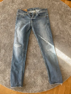 Dondup George - Säljer nu ett par ljusblå Dondup jeans i modellen George. De är i bra skick men lite slitna ner mot anklarna. Storleken är 32 men de är rätt små i storleken så sitter mer som 30 eller 29. Säljer för de inte passar mig. Hör av er vid frågor!
