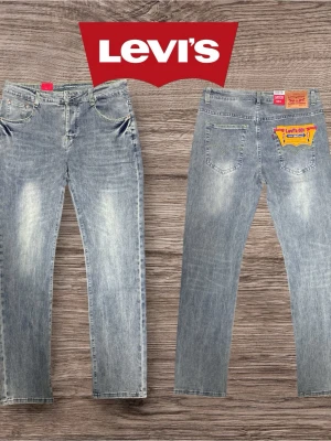 Levi's ljusblå raka jeans - Säljer ett par klassiska ljusblå jeans från Levi's med rak passform och fem fickor. Jeansen har en snygg tvättad look med slitningar på låren och bakfickor med Levi's ikoniska läderpatch. Perfekta till vardags för en avslapp sopad stil. Modellen är 185 och väger 75kg passar nån som är lite större eller mindre :)